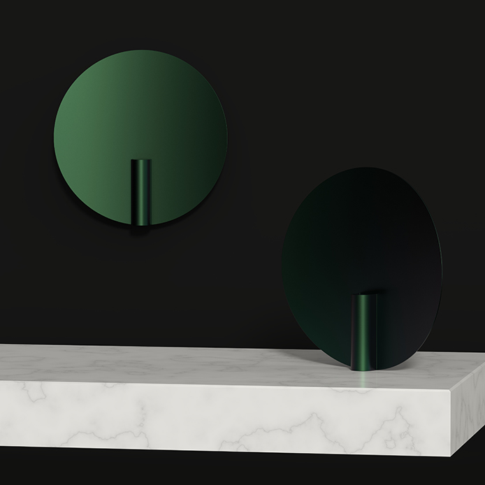 Two dark green nimbus vases, one sitting on a marble plinth, the other on a wall